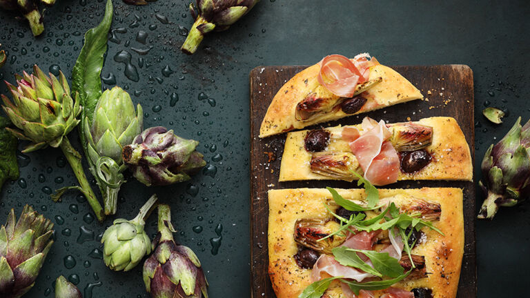 Artischocken-Oliven-Focaccia mit Rucola und Parma-Schinken kann man warm auf der Hand genießen. Artischocken-Oliven-Focaccia mit Rucola und Parma-Schinken